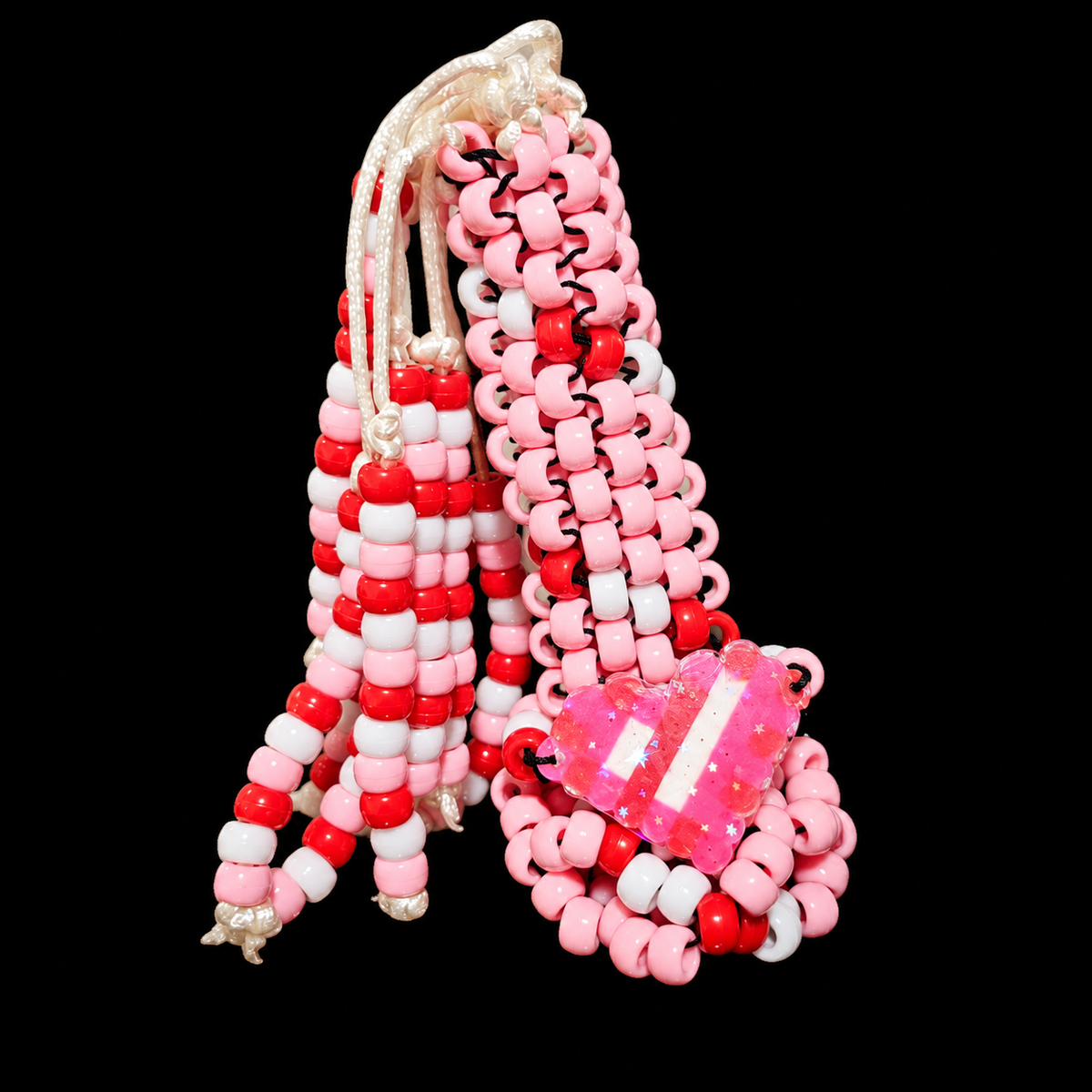 Pink, red and white kandi whip with beaded tails and a large pink heart accent